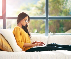 Young woman on a couch using a laptop