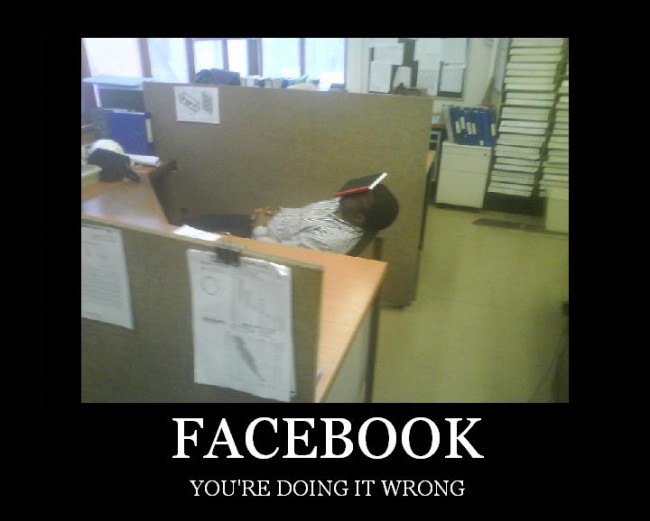 Man in a cubicle with a book on his face